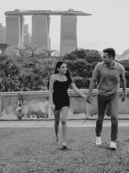 A classic black and white walking portrait with Marina Bay Sands in the background. This timeless style highlights the couple's interaction and the iconic location.