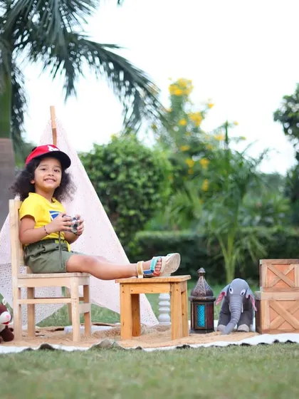 A wide shot of our outdoor adventure theme. This setup, complete with a tent and rustic props, is perfect for capturing a child's curious and playful spirit in a natural environment.