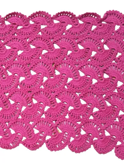 The lacy stole in a beautiful magenta pink, showing the scalloped edge detail created by the shell stitch pattern.