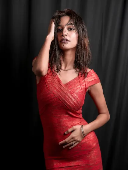A confident pose showcasing the full silhouette of the red bodycon dress, with the model's hand on her hip and a strong, direct look.