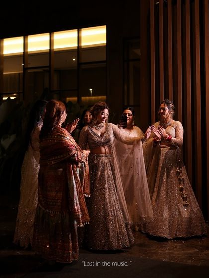 "Lost in the music." A candid shot of the bride and her bridesmaids enjoying the sangeet night. Her sparkling lehenga looks stunning as she dances.
