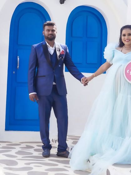 A happy gender reveal photo at the Santorini set. The "It's a girl" sign adds a personal story to the beautiful, picturesque background.