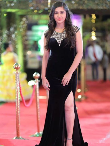 A confident pose on the red carpet, showcasing the elegant silhouette of the black gown.