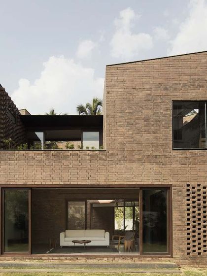 The rear facade of our first completed project, the Brick House in Bangalore. The design uses fully load-bearing, table-moulded brick construction with large sliding doors that open the living space to the garden.