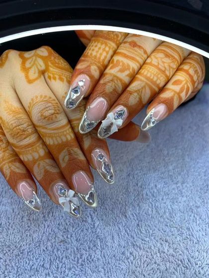 A beautiful fusion of modern and traditional for this bridal client. The silver chrome French tips and 3D bows look stunning against her intricate henna design.