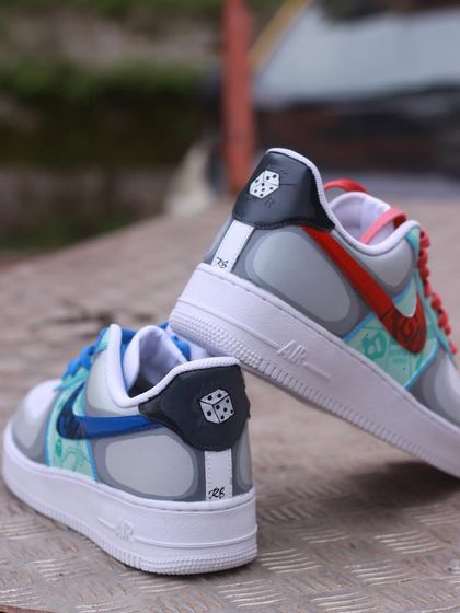 A pair of Air Force 1s inspired by board games: Monopoly and Scotland Yard. Each shoe has a different theme, with custom red and blue swooshes.