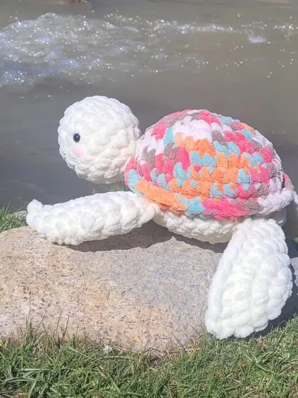 This is Olly the turtle on its first vacation. I love seeing my creations go on adventures. This one has a custom multi-colored shell and is made with chunky, soft yarn, making it a perfect travel buddy.