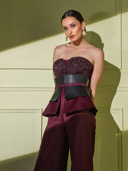 For a bold and structured look, I designed this strapless corset with a peplum waist and a wide leather belt. Paired with matching maroon trousers, it's a perfect blend of modern tailoring and couture detailing.
