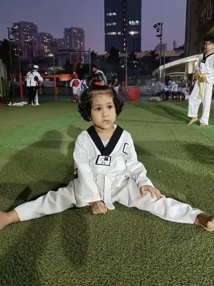 A quiet moment of focus. Even during a busy class, this young student maintains her stretching posture, demonstrating the discipline we instill from day one.