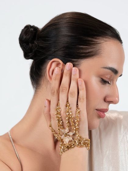 A model showcasing our golden hand harness, a piece that adds instant grace and elegance to your hands.