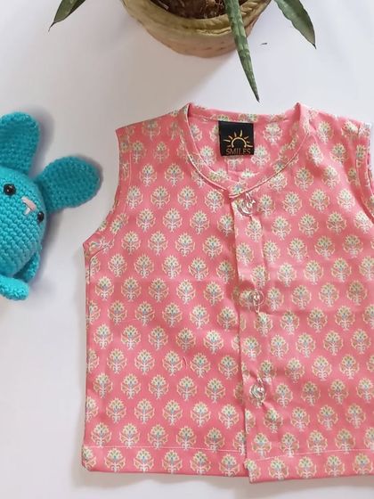 Introducing our simple jhablas for newborns in a lovely pink block print. They feature front-open buttons for ease of wear and are made from the softest cotton.