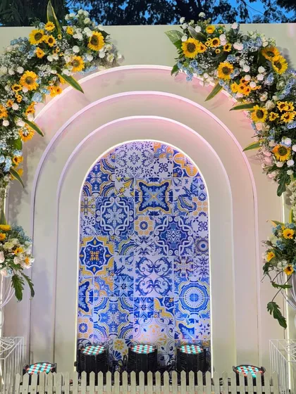 For a unique Haldi, I designed this backdrop combining Moroccan blue tiles with bright yellow sunflowers. The arched panels create a beautiful contrast and a vibrant setting.