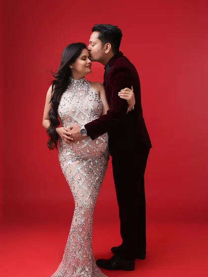 A classic and elegant couple's portrait. His tender kiss on her forehead and their formal attire create a sophisticated and romantic image.