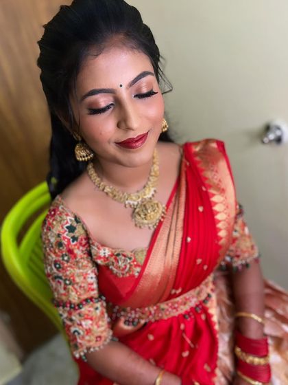 A classic look with bold red lips and a simple hairstyle, perfect for a family pooja or function.