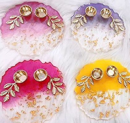 A collection of colorful resin platters designed for Rakhi. Each platter features a unique color blend, gold leaf accents, and attached golden bowls for festive essentials.