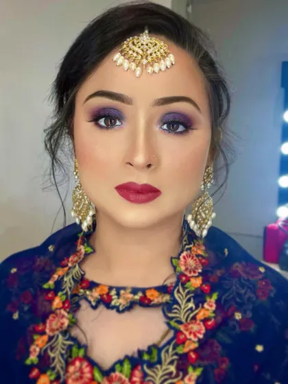 A stunning blue smokey eye paired with a bold red lip. This is a classic combination for a glamorous evening event, perfect for Eid or any festive celebration.