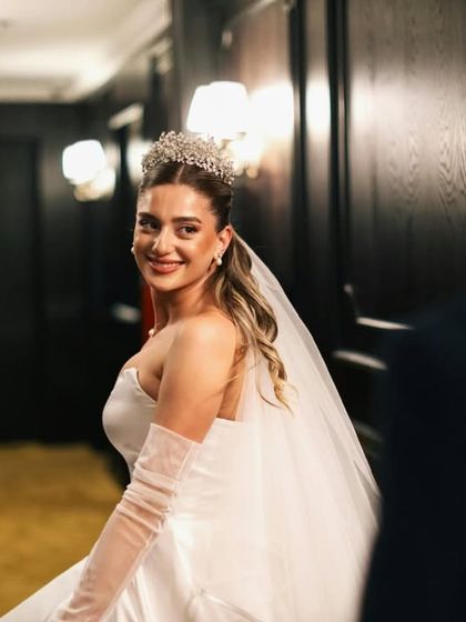 A beautiful "first look" style shot, capturing the bride's radiant smile as she turns towards the groom. It's a moment filled with love and anticipation.