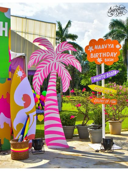 Custom signage is key to a themed event. This fun, hand-painted signpost directed guests to the photo booth and other fun zones at the summer party.