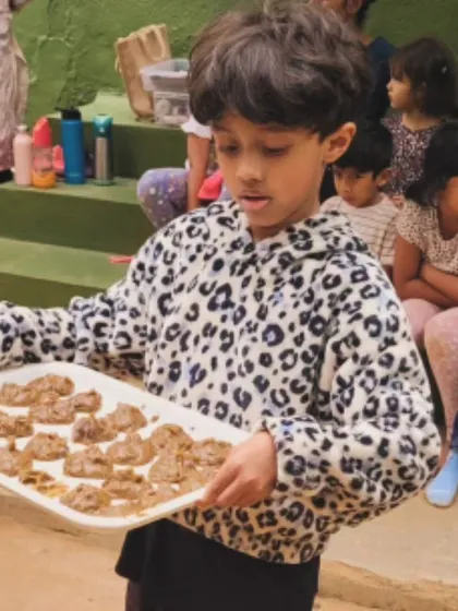 A child proudly presents a tray of "mersu," a recreation of an ancient Mesopotamian recipe found on a clay tablet. This project was a spontaneous fusion of history, geometry, and cooking.
