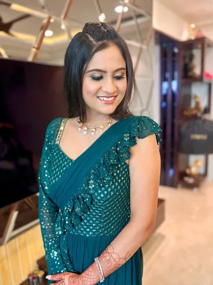 A closer look at the soft smokey eye and glowing skin that complements the deep teal color of her dress.