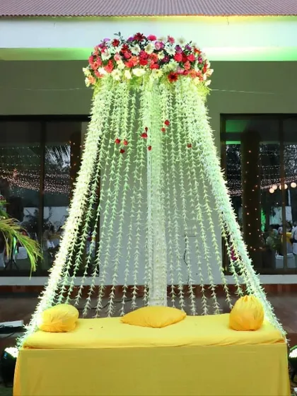 A beautiful bridal seat for a Mehendi or Haldi ceremony. We created a canopy of falling white flowers topped with a crown of colorful blooms, making the bride the center of attention.