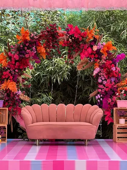 Creating the perfect photo opportunity is one of our specialties. For this Mehendi, we designed a vibrant seating area with a stunning floral arch in shades of pink and orange, a stylish scalloped sofa, and colorful accents that looked incredible in photos.