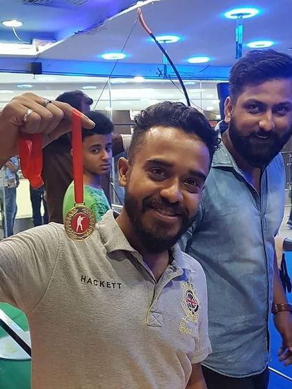 A happy customer shows off his archery medal. We provide a supportive environment for archers of all levels to achieve their personal best.