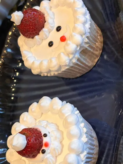 Adorable Santa-themed cupcakes, made with fresh strawberries for Santa's hat. These are a fun and festive addition to any Christmas party.