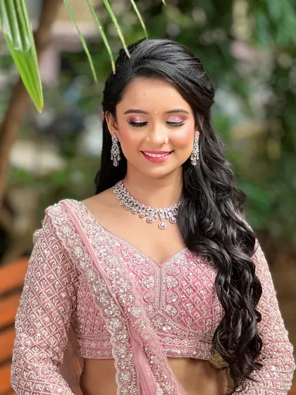 For the modern bride who loves a soft, romantic glow. This delicate diamond necklace and earring set is perfect for an engagement or reception. It provides that touch of sparkle without overpowering the intricate details of the pink lehenga.