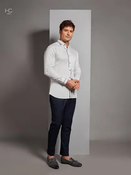 A full-length view of the detailed white shirt, paired with navy trousers. It's a versatile look that works for any occasion, from the office to a dinner party.