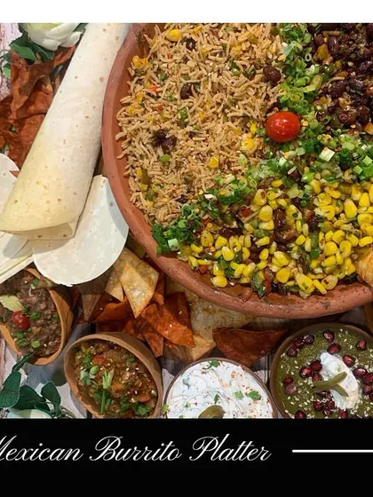 My Mexican Burrito Platter is a deconstructed feast. It includes Mexican rice, beans, corn, and various dips like salsa and sour cream, with soft tortillas on the side.