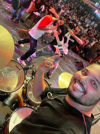 A selfie from the drum kit, capturing the band and the energetic crowd at the Ernst & Young corporate gig.