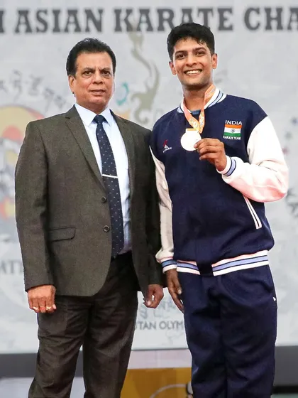 Standing with Pranay Sharma on the podium at the South Asian Karate Championship. A proud moment for a coach and a father.