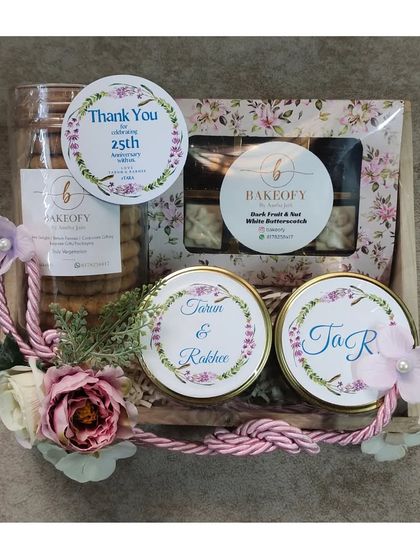 Another view of the elegant 25th-anniversary return hamper. The combination of rustic wooden trays, floral decorations, and personalized labels creates a truly memorable gift for any milestone.