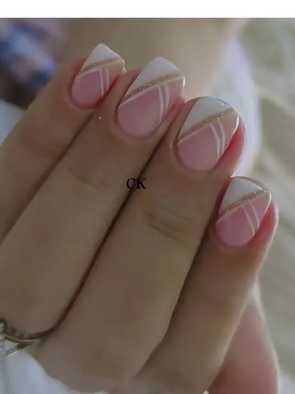 A still image of the geometric French manicure, showing the precise line work with gold glitter and white polish.