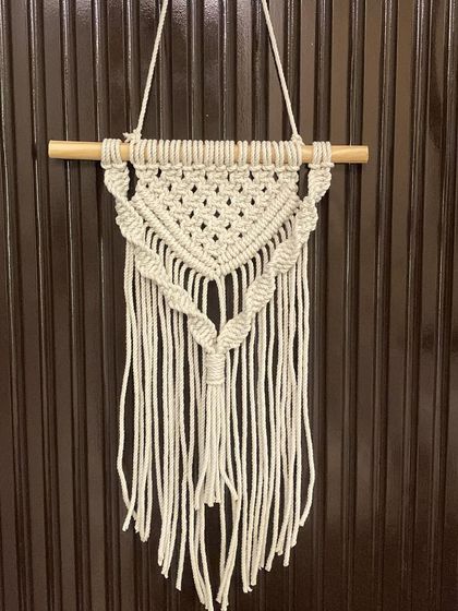 This small, triangular wall hanging is another great option for smaller spaces. It has a dense, textured top section that flows into a simple fringe.