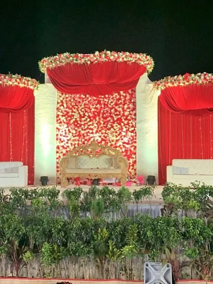 A night view of the grand red wedding stage, where the lighting brings the entire structure to life. The rich colors create a warm and celebratory feel.