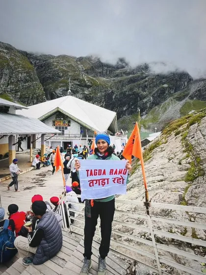 A member of the Tagda Tribe proudly displays our flag at a high-altitude pilgrimage site. This shows that the strength and spirit built in our dugouts travel with our members, supporting them on their personal journeys, wherever they may lead.