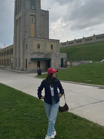 A wider shot that includes the interesting architecture of the location, blending fashion with local scenery.