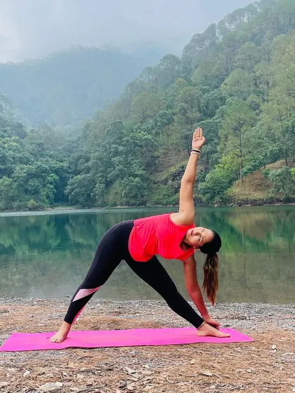 Yoga is a lifelong exploration of the body and mind. Here I am in Trikonasana, or Triangle Pose, by a serene lake, a posture that strengthens the legs and torso while improving balance.