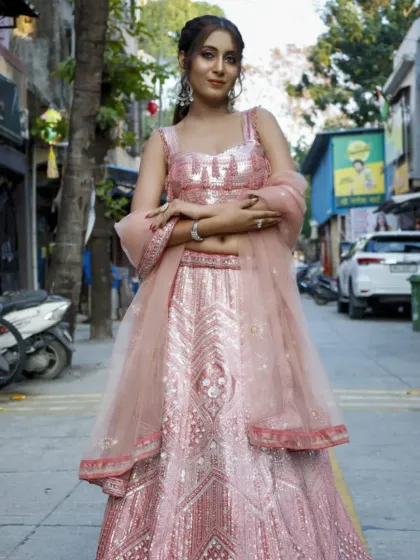 This rose gold and pink lehenga is pure glamour. The intricate sequin work shines from every angle, making it an ideal outfit for a bridesmaid or a wedding guest who wants to stand out.