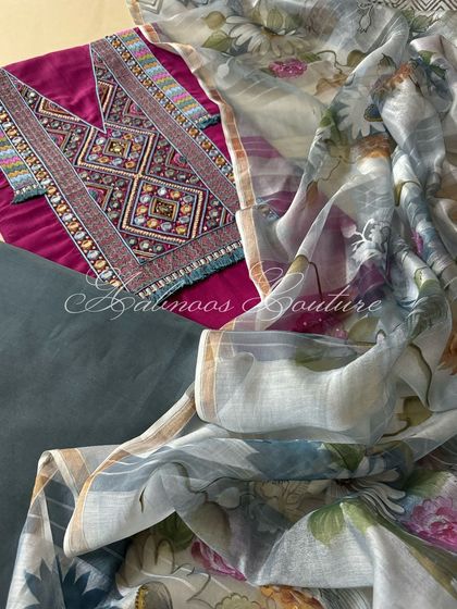 The complete three-piece set is displayed, including the deep berry kurta, a coordinating solid bottom, and the ethereal hand-painted floral dupatta.