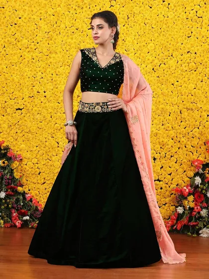 The deep green velvet and soft peach dupatta create a beautiful and unexpected color story.