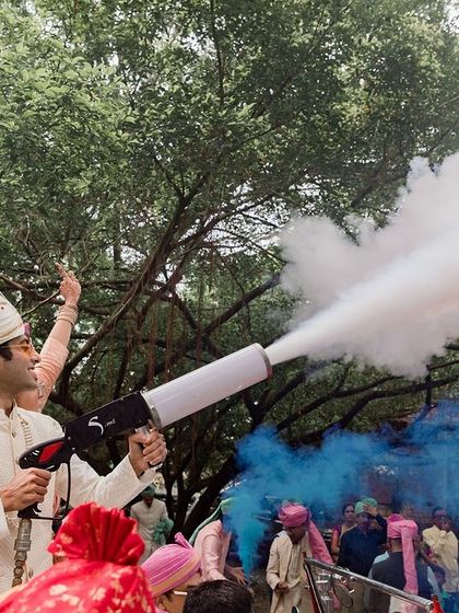 The groom makes a grand, fun-filled entrance with a smoke cannon, adding a modern and festive touch to the celebration.