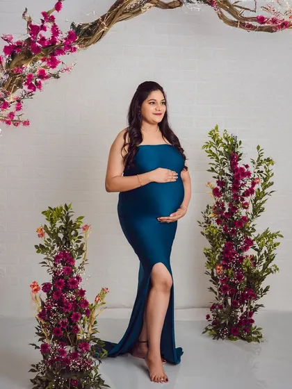For a simpler look, we styled the same teal gown without the ruffled cape. This strapless style creates a sleek and modern maternity portrait.