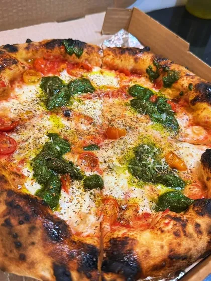 Another look at the Burrata Pesto Pizza, ready to be devoured. The combination of the creamy cheese, herby pesto, and perfectly baked crust is a true crowd pleaser.