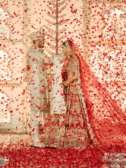 A shower of red petals during the varmala ceremony creates a dramatic and romantic effect, making the moment truly unforgettable.