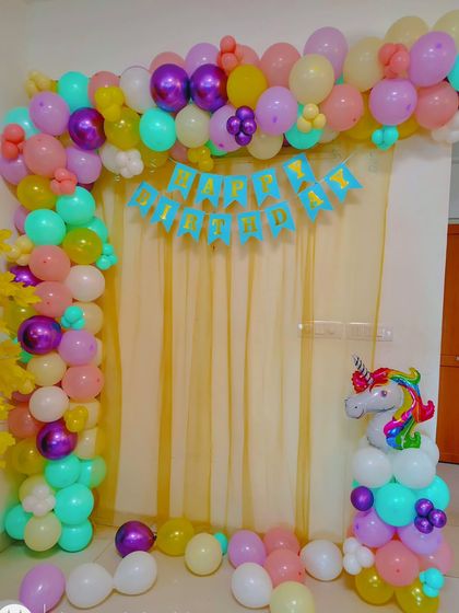 Another view of the unicorn-themed balloon arch against a simple curtain backdrop. This is an affordable way to create a festive photo corner at home.