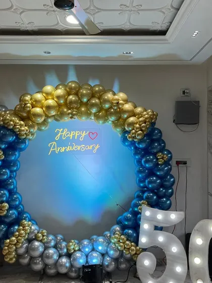 This is a grand backdrop I created for a 50th anniversary party. The large balloon ring in blue, gold, and silver, combined with light-up marquee numbers, makes for a perfect photo spot to celebrate a major milestone.