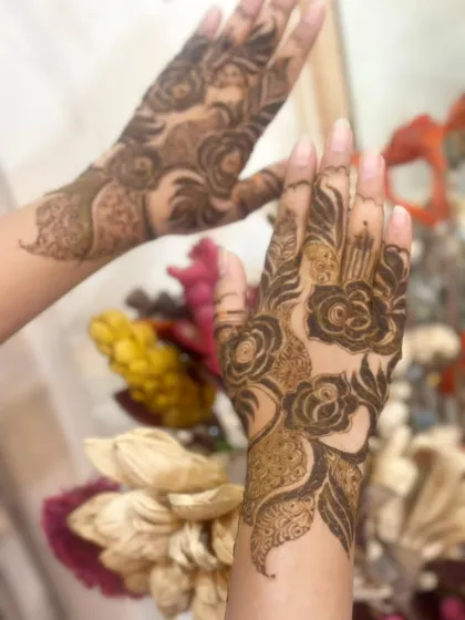 A modern take on floral henna, with bold rose outlines and leafy accents.